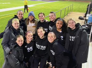 Coach Walker (in the blue beanie) with the PHS class of '24 seniors after a varsity girls soccer game. 